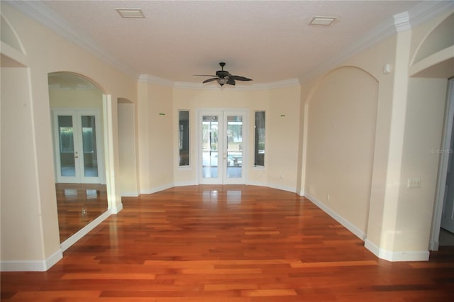 empty room with ornamental molding, hardwood / wood-style floors, a textured ceiling, and french doors