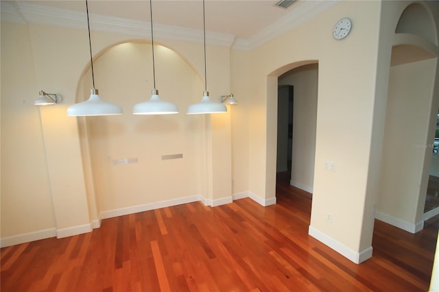 empty room with crown molding and wood-type flooring