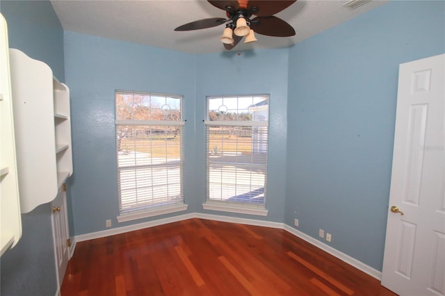 unfurnished room featuring dark hardwood / wood-style floors and ceiling fan