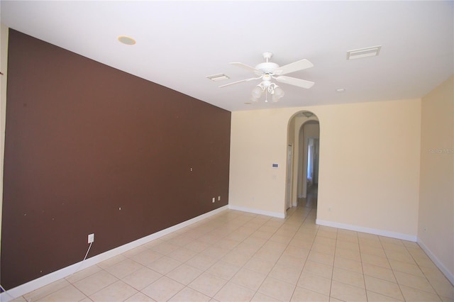 spare room with ceiling fan and light tile patterned floors