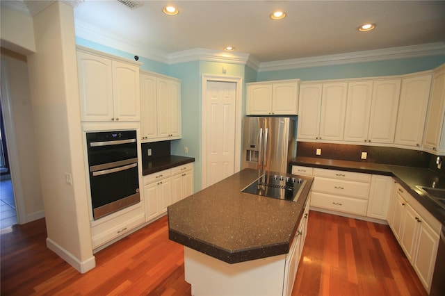 kitchen with white cabinetry, ornamental molding, a center island, and black appliances