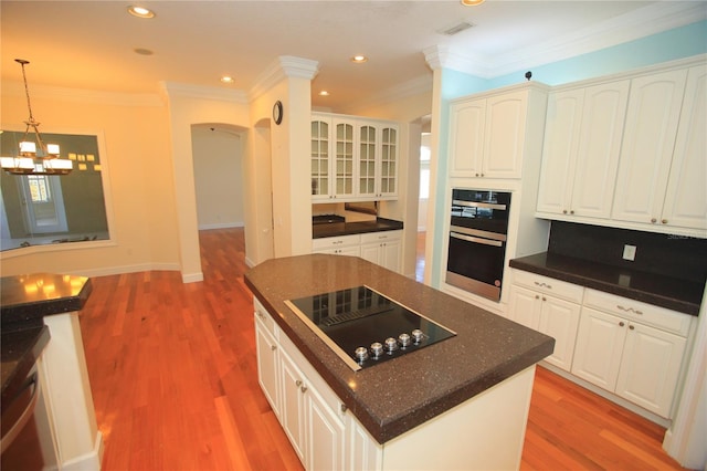 kitchen with white cabinetry, hanging light fixtures, and black appliances