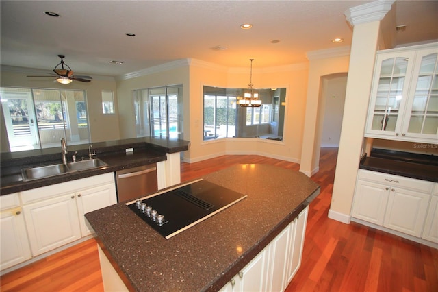 kitchen with sink, dishwasher, white cabinetry, a center island, and black electric stovetop