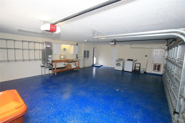 garage with a garage door opener, washer and clothes dryer, and electric panel