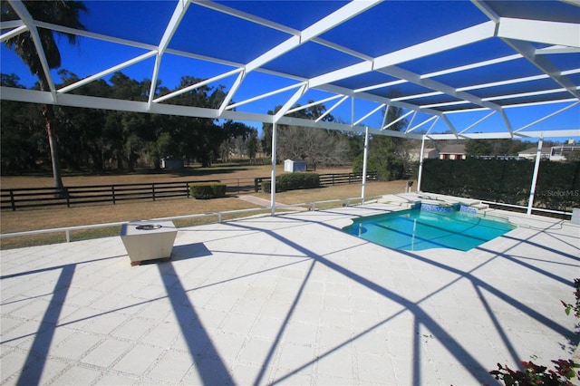 view of swimming pool featuring glass enclosure and a patio area