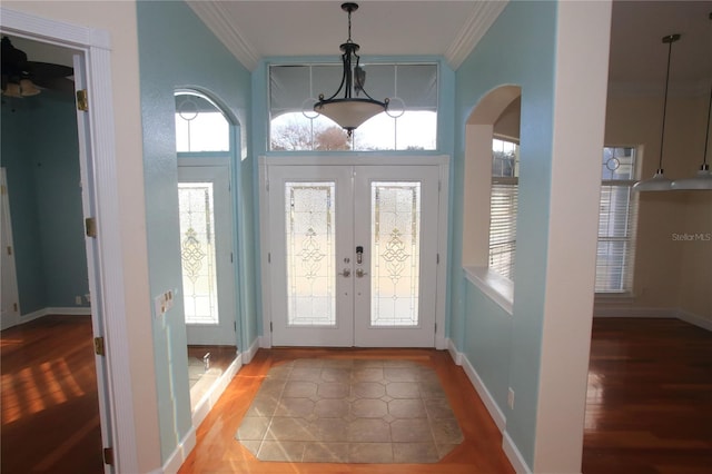 foyer entrance featuring french doors, ornamental molding, wood-type flooring, and plenty of natural light