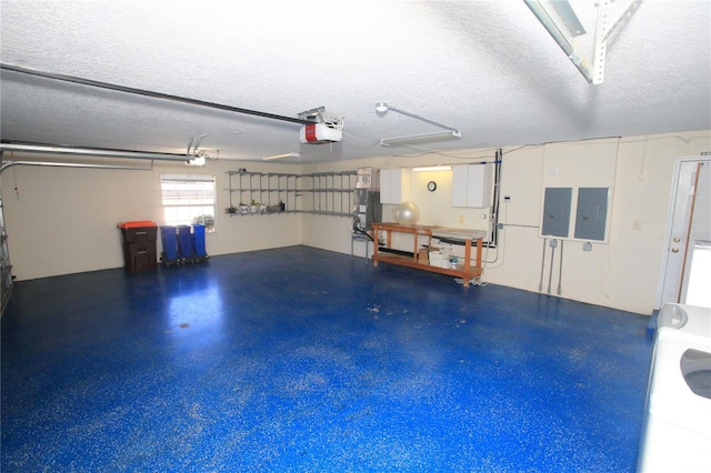 garage with a garage door opener, washer / dryer, and electric panel