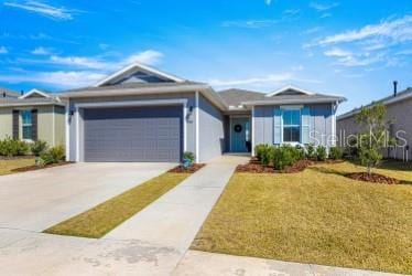 ranch-style house featuring a garage and a front lawn