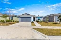 single story home with a garage and a front lawn