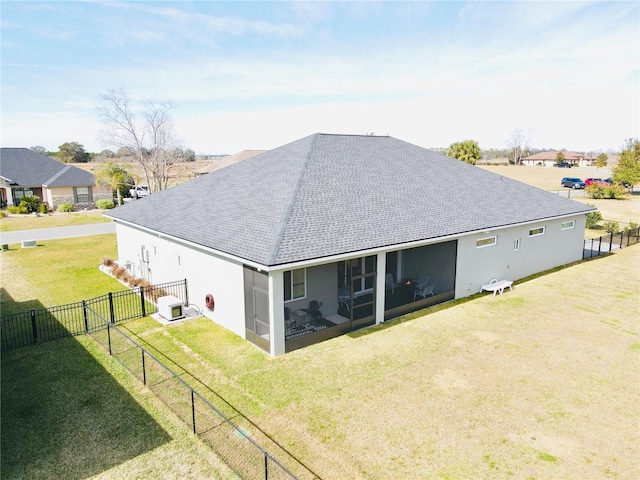 rear view of house featuring a sunroom and a yard