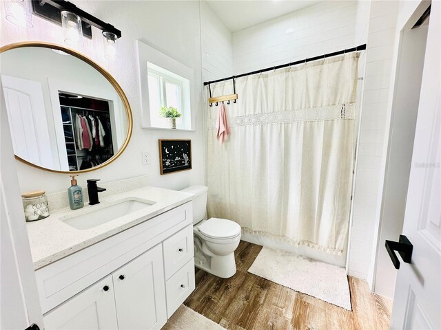 full bathroom with toilet, hardwood / wood-style flooring, vanity, and shower / tub combo with curtain