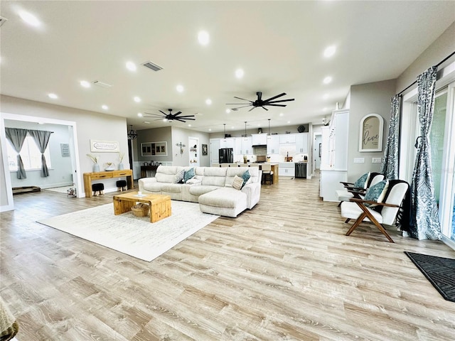 living room with ceiling fan and light hardwood / wood-style flooring