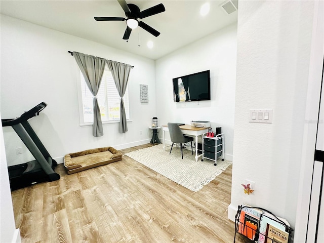 exercise room featuring ceiling fan and hardwood / wood-style flooring