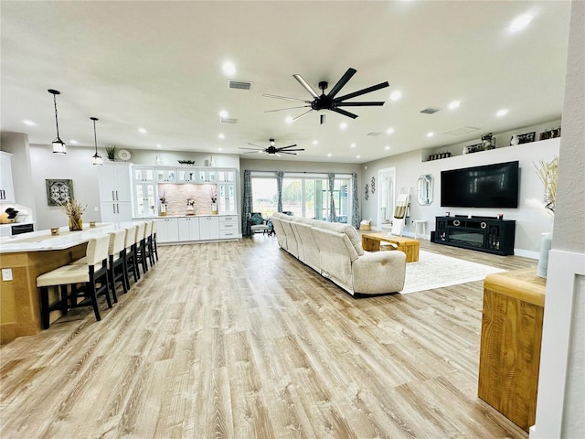 living room featuring ceiling fan and light hardwood / wood-style flooring