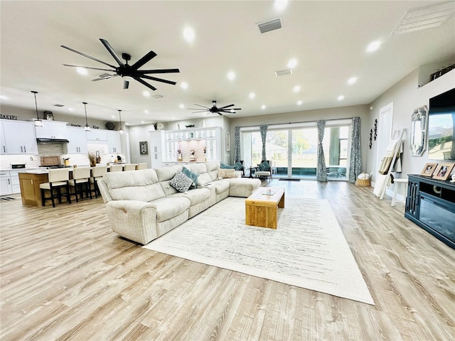 living room with ceiling fan and light wood-type flooring