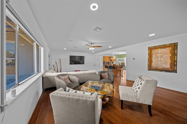 living room featuring ceiling fan and dark hardwood / wood-style floors