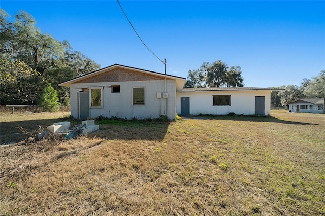 back of house featuring a lawn