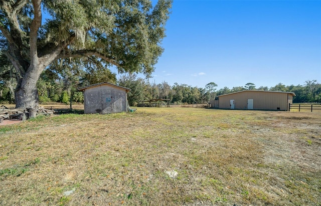 view of yard featuring a rural view and a shed