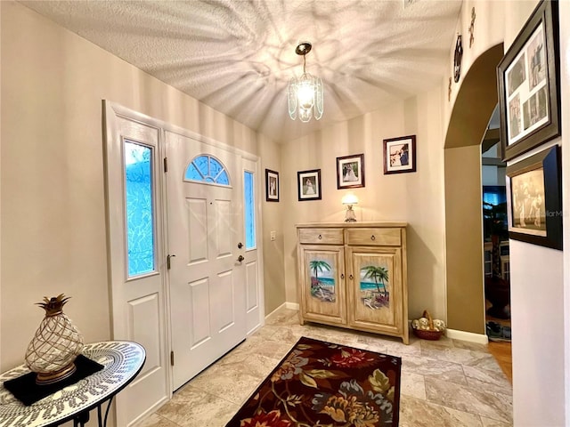 foyer entrance with a textured ceiling