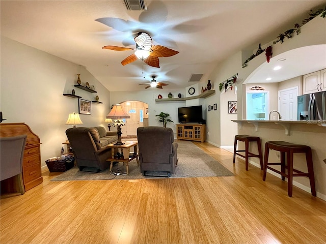 living room with vaulted ceiling, ceiling fan, and light hardwood / wood-style flooring