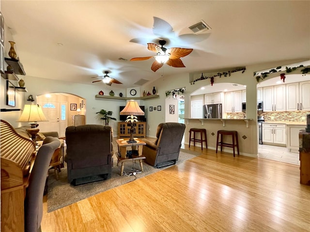 living room featuring ceiling fan and light hardwood / wood-style floors