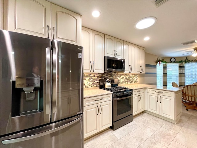 kitchen with kitchen peninsula, stainless steel appliances, ceiling fan, light tile patterned floors, and decorative backsplash