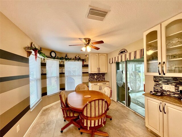 dining room with a textured ceiling, ceiling fan, and light tile patterned floors