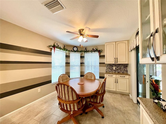 dining space featuring a textured ceiling and ceiling fan