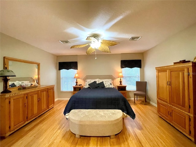 bedroom featuring ceiling fan, light hardwood / wood-style flooring, and multiple windows