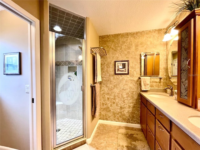 bathroom featuring a textured ceiling, vanity, walk in shower, and tile patterned flooring