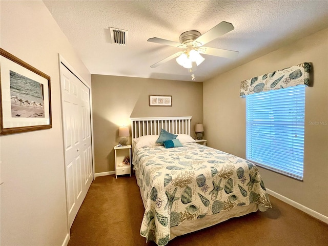 carpeted bedroom featuring ceiling fan, a textured ceiling, and a closet