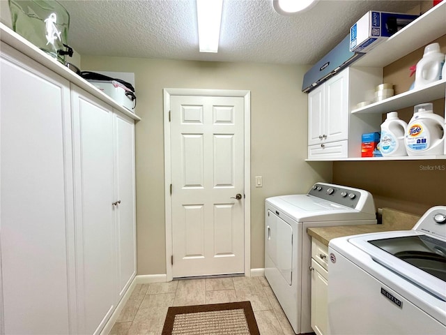 laundry area with separate washer and dryer, cabinets, and a textured ceiling