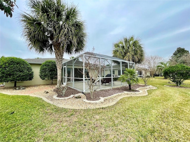 rear view of property with a patio area, a yard, and a lanai