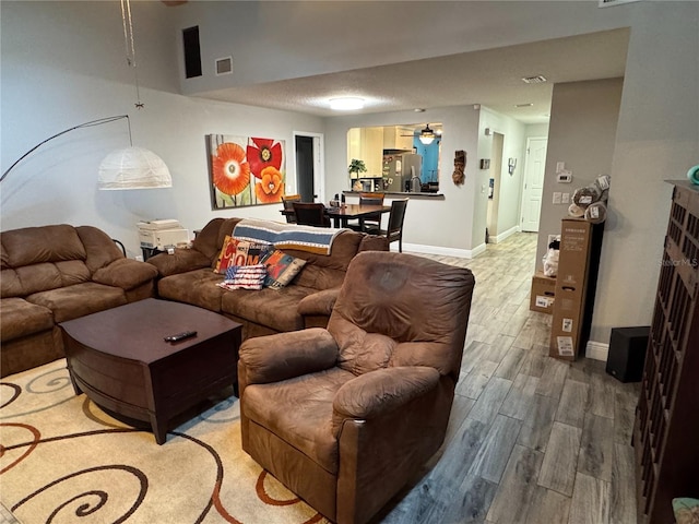 living room with ceiling fan and wood-type flooring