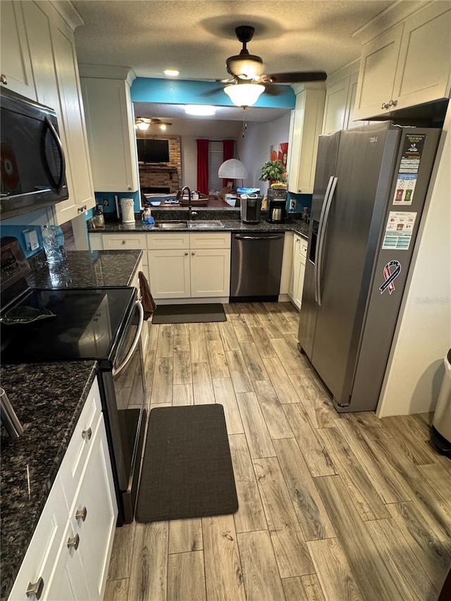 kitchen featuring a textured ceiling, stainless steel appliances, light hardwood / wood-style flooring, and sink