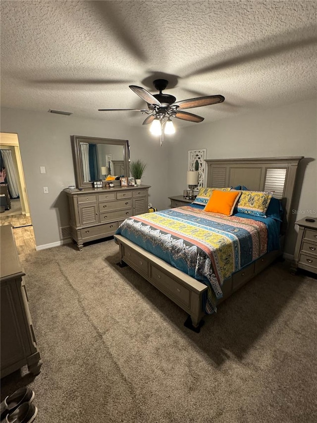 bedroom featuring ceiling fan, carpet, and a textured ceiling