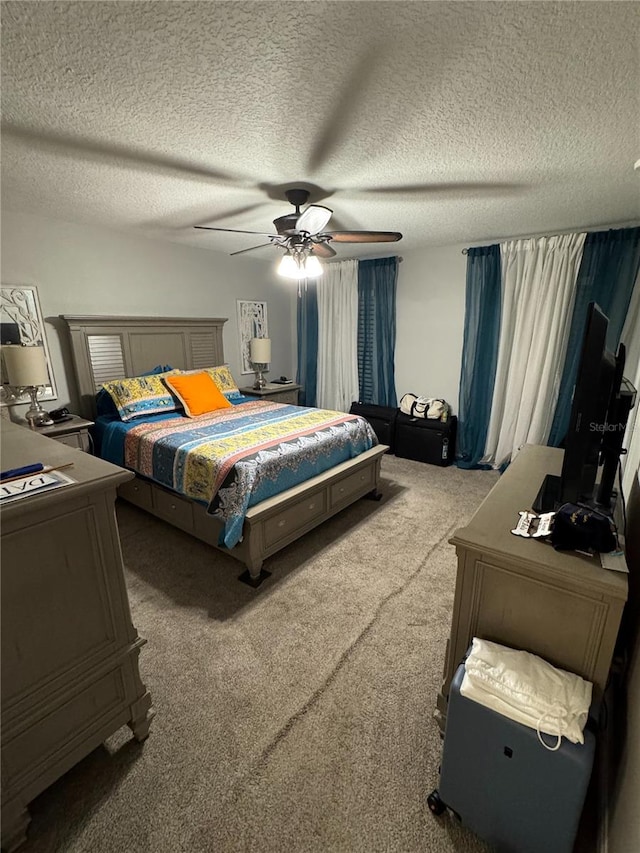 carpeted bedroom featuring ceiling fan and a textured ceiling