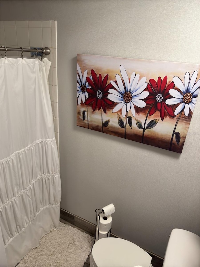 bathroom featuring toilet and walk in shower