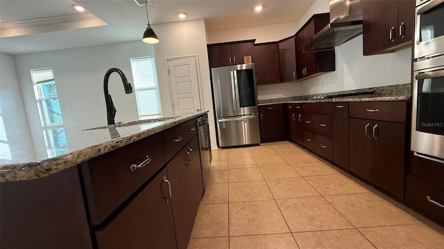 kitchen featuring sink, light tile patterned floors, dark brown cabinetry, black appliances, and wall chimney exhaust hood