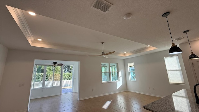 interior space featuring a textured ceiling, light tile patterned floors, ornamental molding, a raised ceiling, and ceiling fan