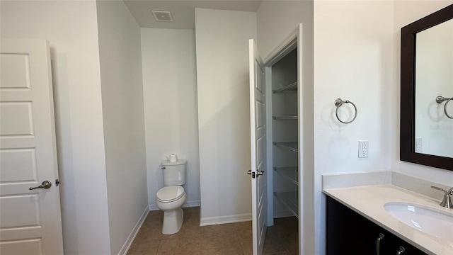 bathroom with tile patterned flooring, vanity, and toilet