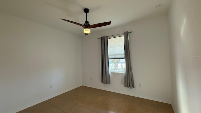 tiled empty room featuring ceiling fan