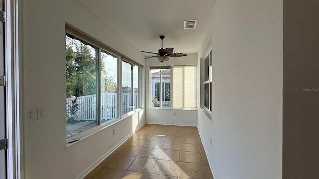 unfurnished sunroom featuring ceiling fan