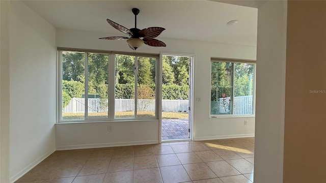 doorway featuring light tile patterned floors and ceiling fan