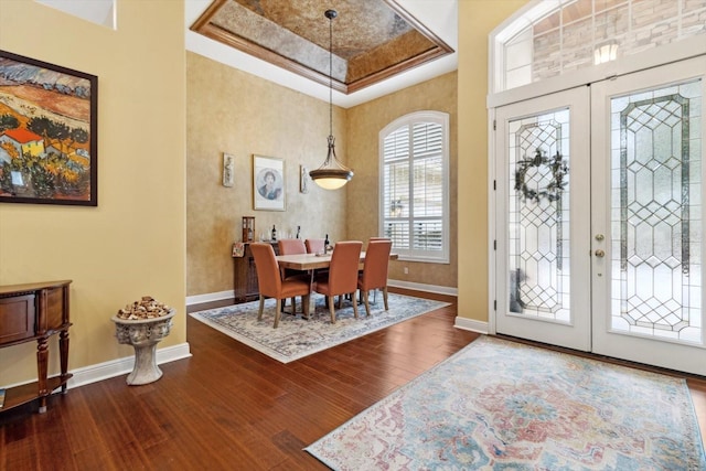 foyer entrance featuring french doors, wood-type flooring, and a raised ceiling