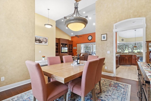 dining space with high vaulted ceiling and dark hardwood / wood-style flooring