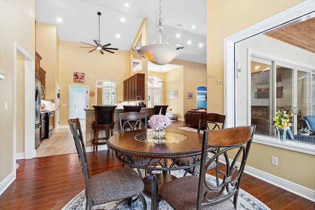 dining area featuring hardwood / wood-style flooring, high vaulted ceiling, and ceiling fan