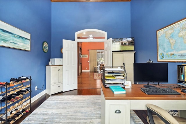 office with a high ceiling, dark hardwood / wood-style floors, and ceiling fan