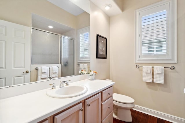 bathroom featuring vanity, toilet, a shower with door, and hardwood / wood-style floors