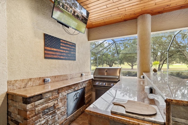 view of patio / terrace featuring exterior kitchen, grilling area, and glass enclosure